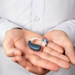 hands-holding-hearing-aids-front-view