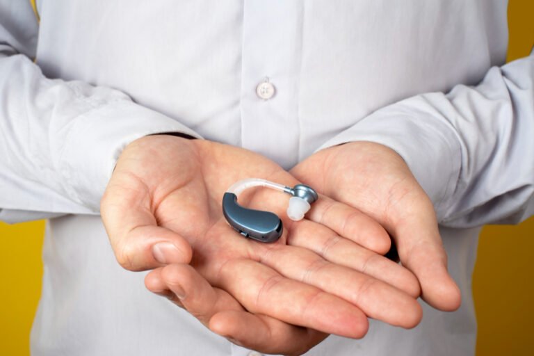 hands-holding-hearing-aids-front-view