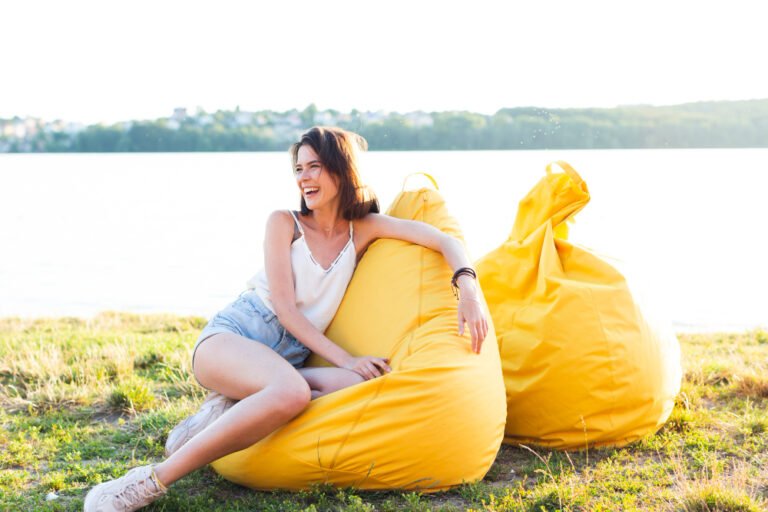 long-shot-beautiful-woman-posing-yellow-beanbag