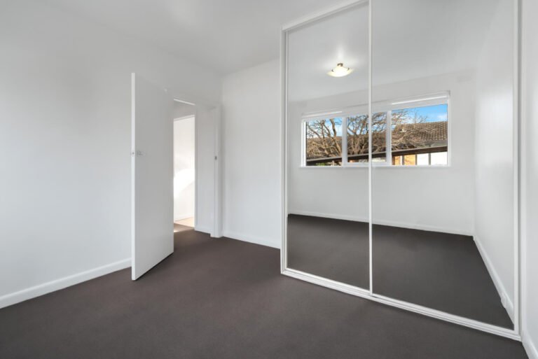 corner-empty-new-room-with-white-walls-wardrobe-with-mirror-sliding-doors