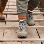 close-up-couple-s-feet-wooden-bridge_23-2148693719