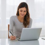 Beautiful,Young,Freelancer,Woman,Using,Laptop,Computer,At,Home.,Happy